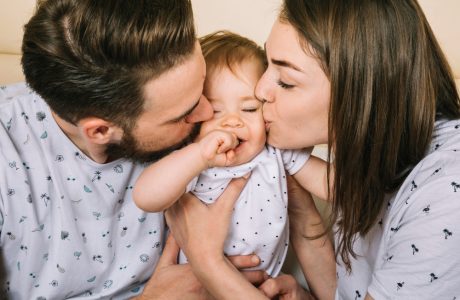 Parents kissing their baby